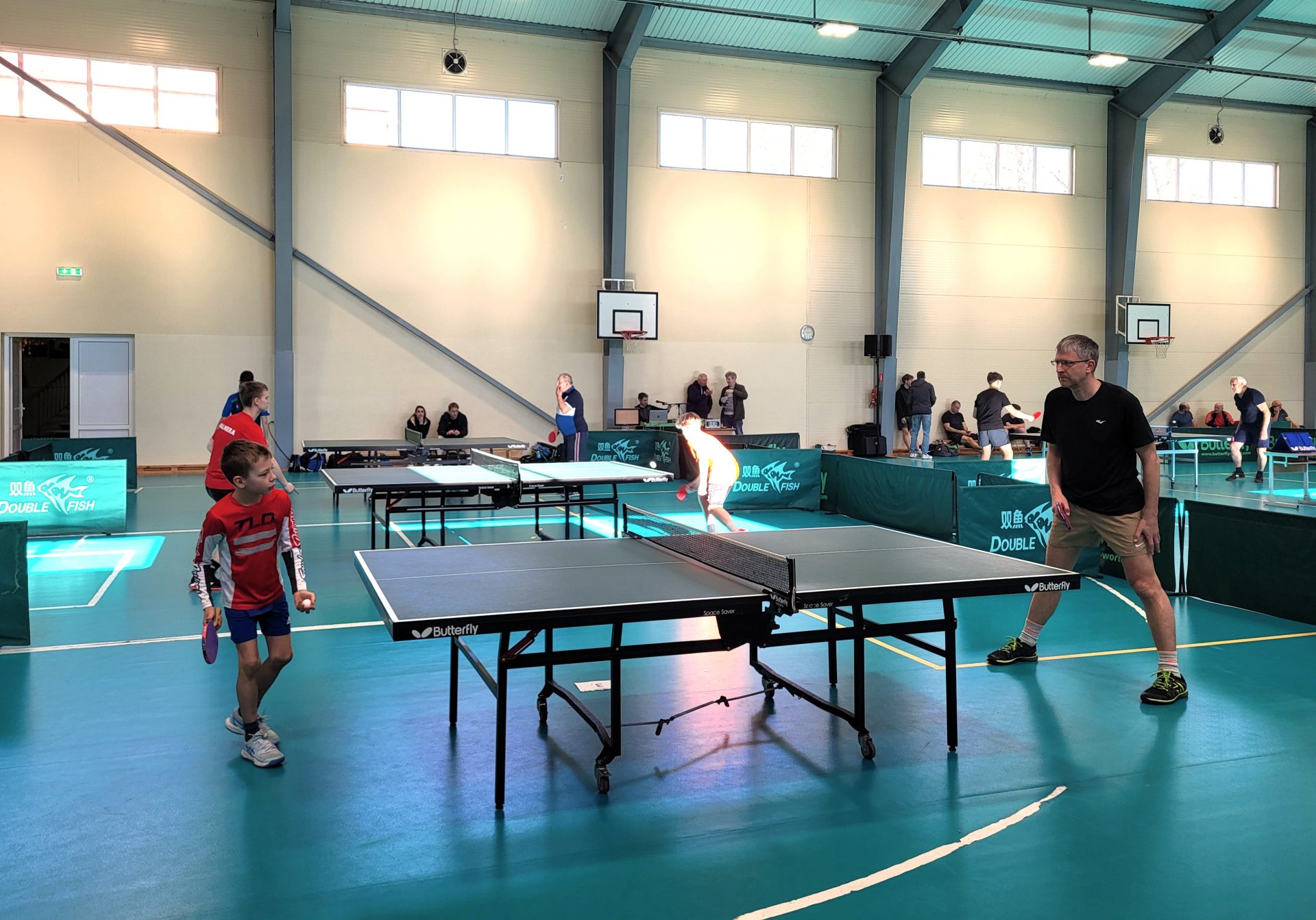 Galda tenisa spēlētāji sporta zālē